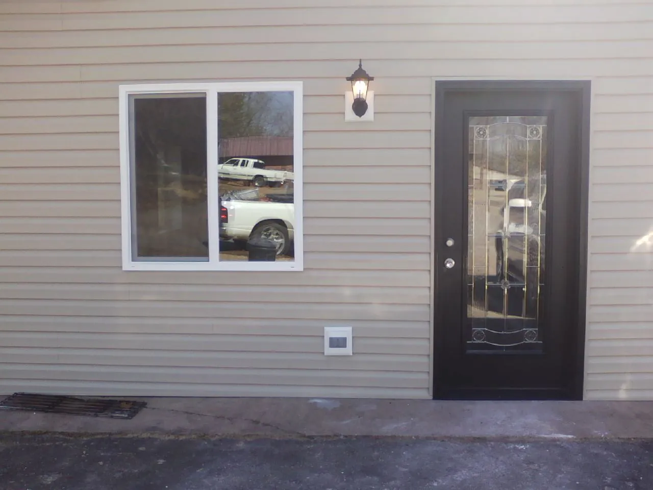 New siding, window and entry door on the side of an addition in Hanceville
