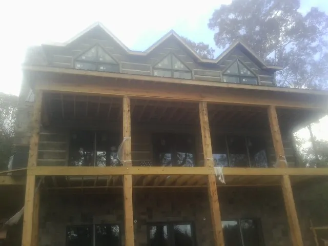 Dormers and porch framing on a large log home under construction — Roof Coating work by our crew in Hanceville