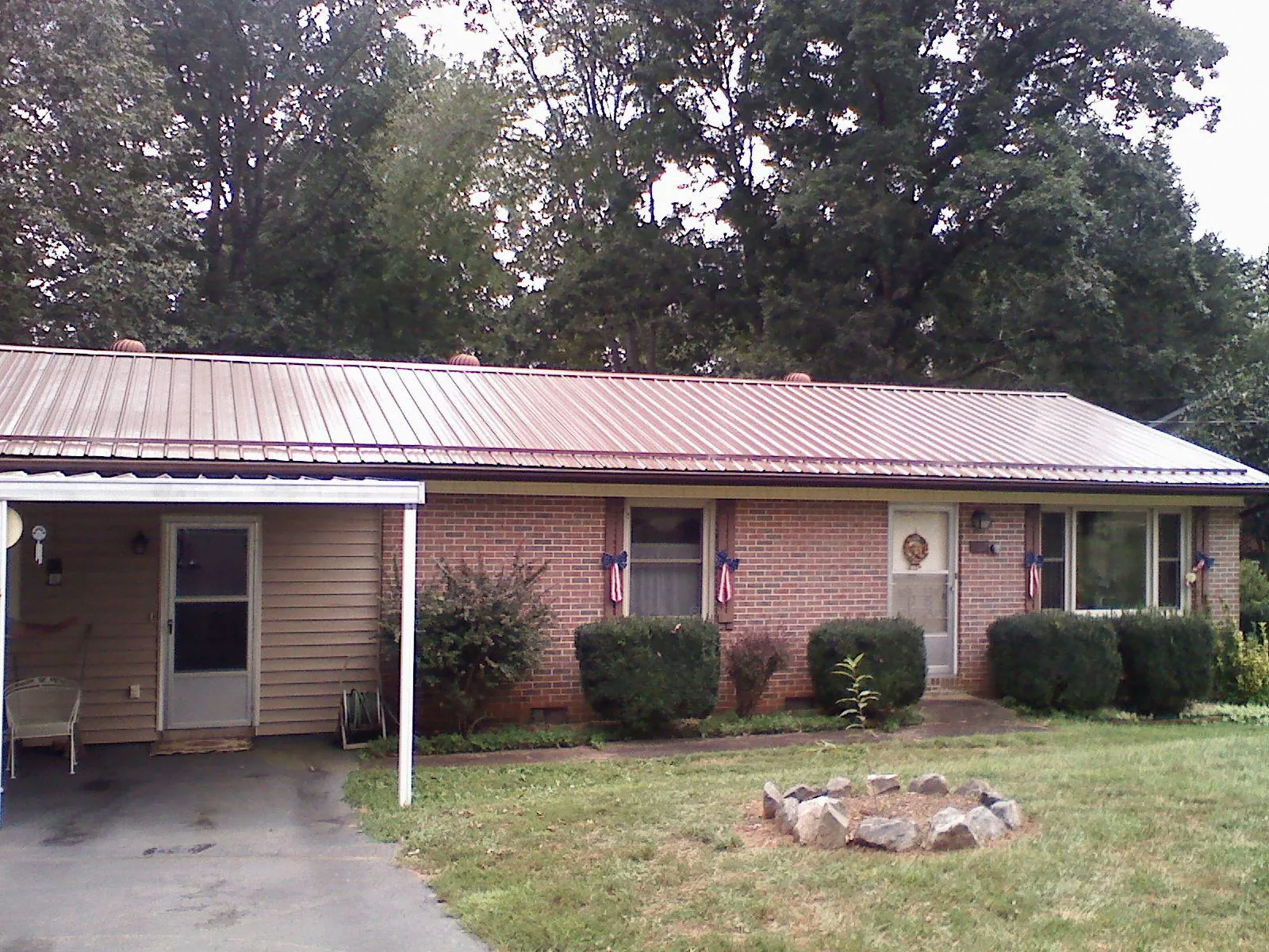 Bronze metal roof and carport on a brick ranch home — Roof Repair work by our crew in Hanceville