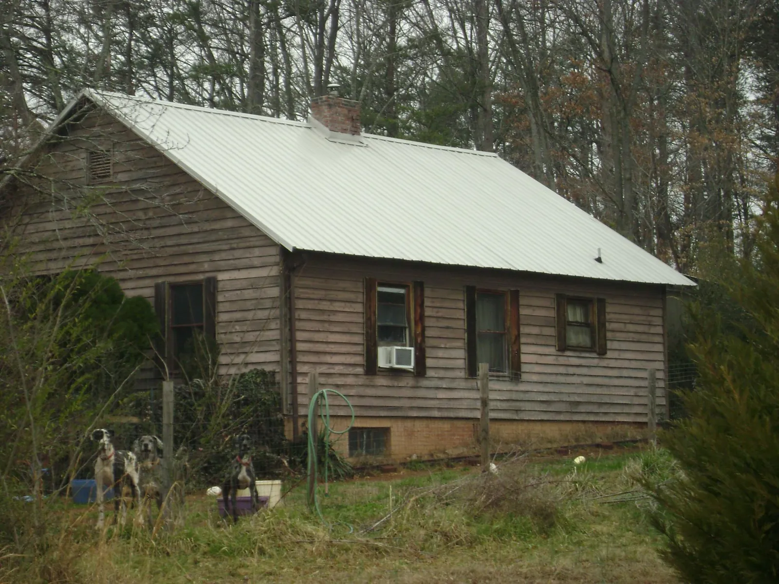 White metal roof on an old wood sided farmhouse, from a Metal Roof Installation job in Hanceville
